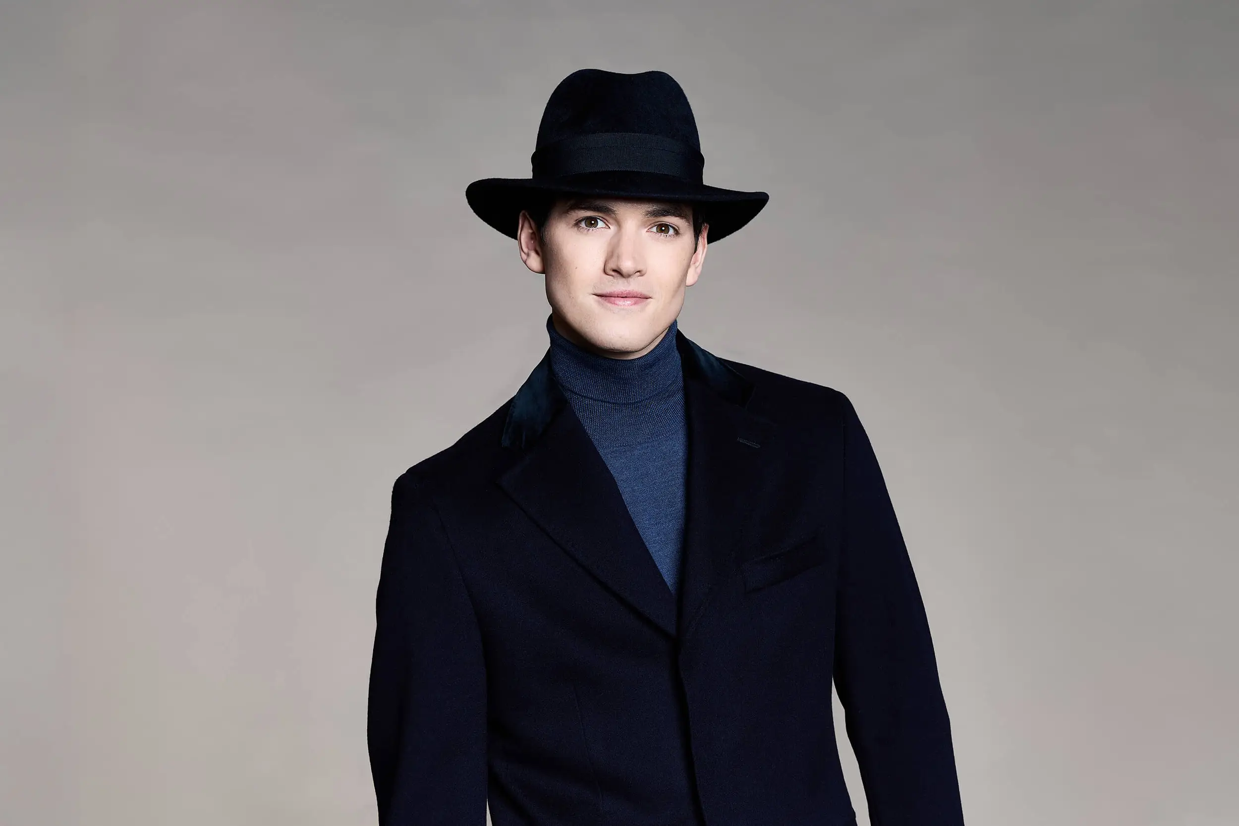 man wearing a dark navy blue hat over a matching coat