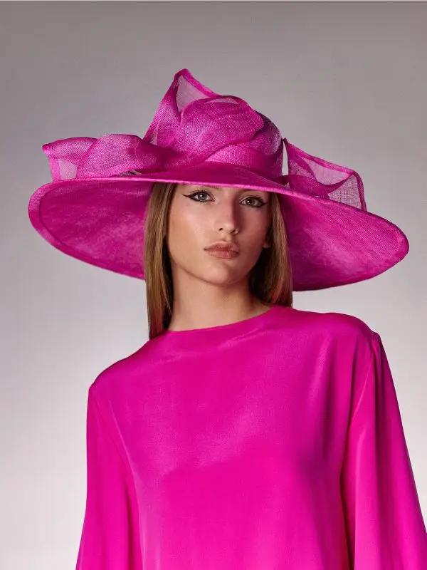 Woman wearing the Fuchsia pink Abelia cloche hat made of banana fibre