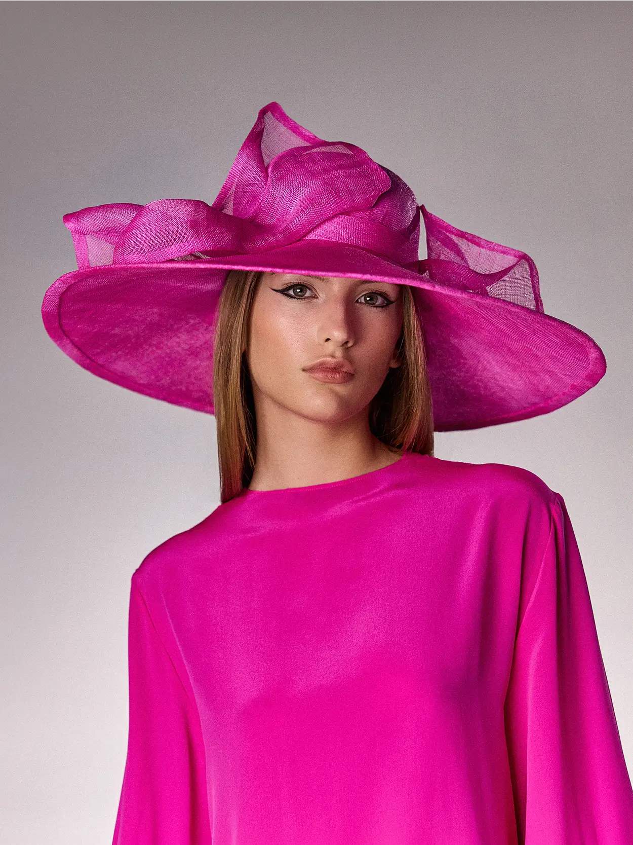 Woman wearing the Fuchsia pink Abelia cloche hat made of banana fibre