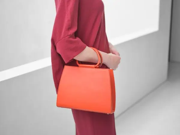 Mannequin wearing the Bella orange leather everyday handbag accessory