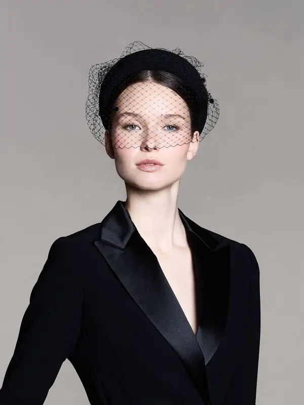 Woman wearing a black headband with a veil over her eyes