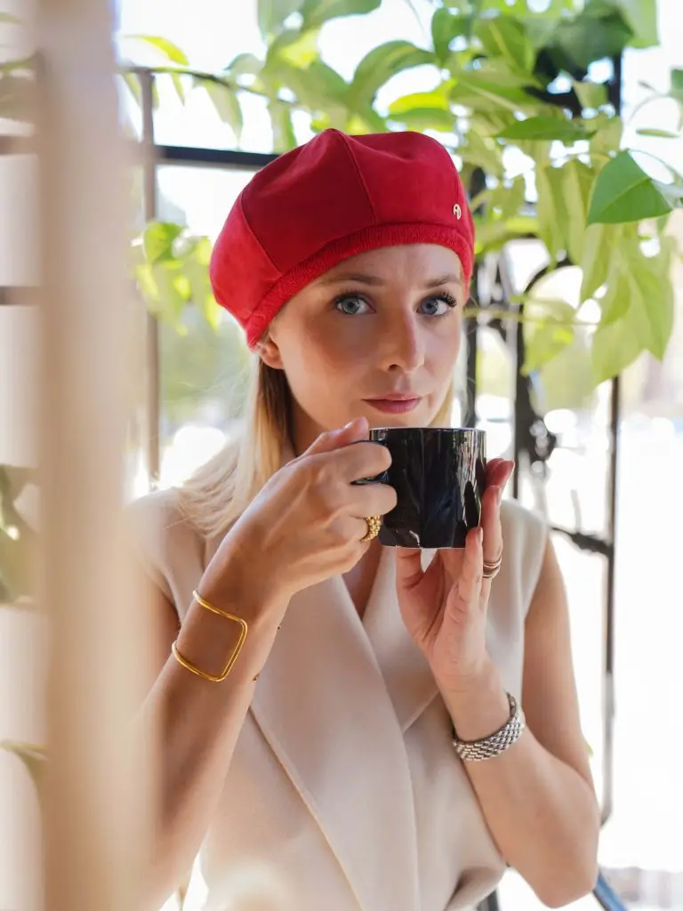 Woman wearing the red poppy hat in a cafe