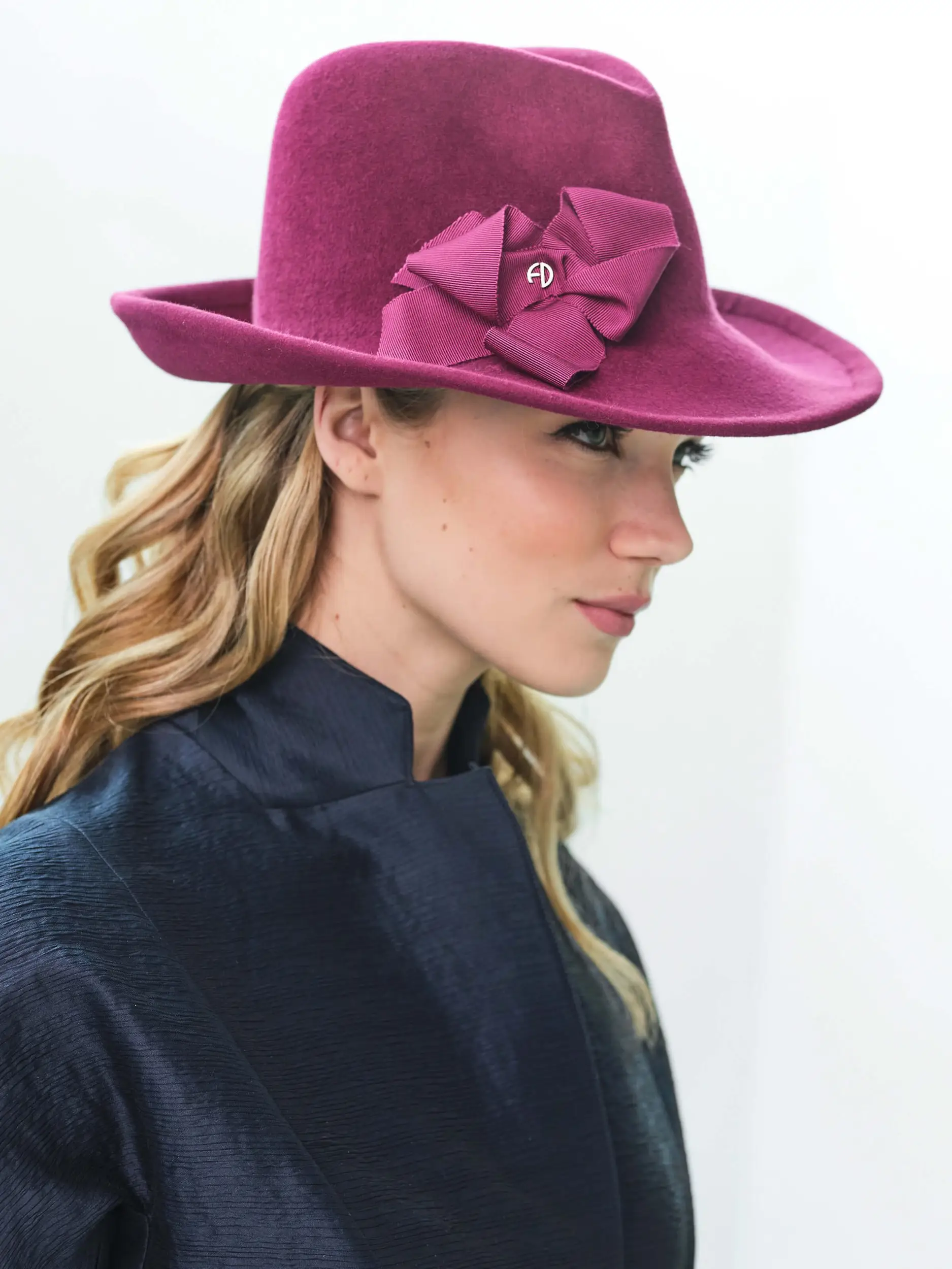 Side woman wearing the Raphaelle felted fedora in violin color