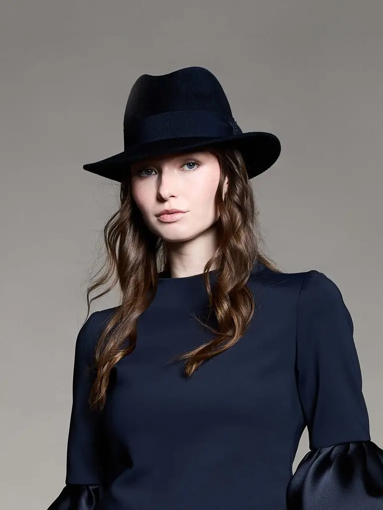 man wearing a dark navy blue hat over a matching coat