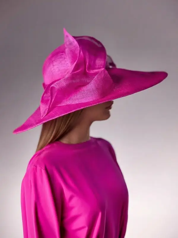 Woman wearing the Fuchsia pink Abelia cloche hat made of banana fibre