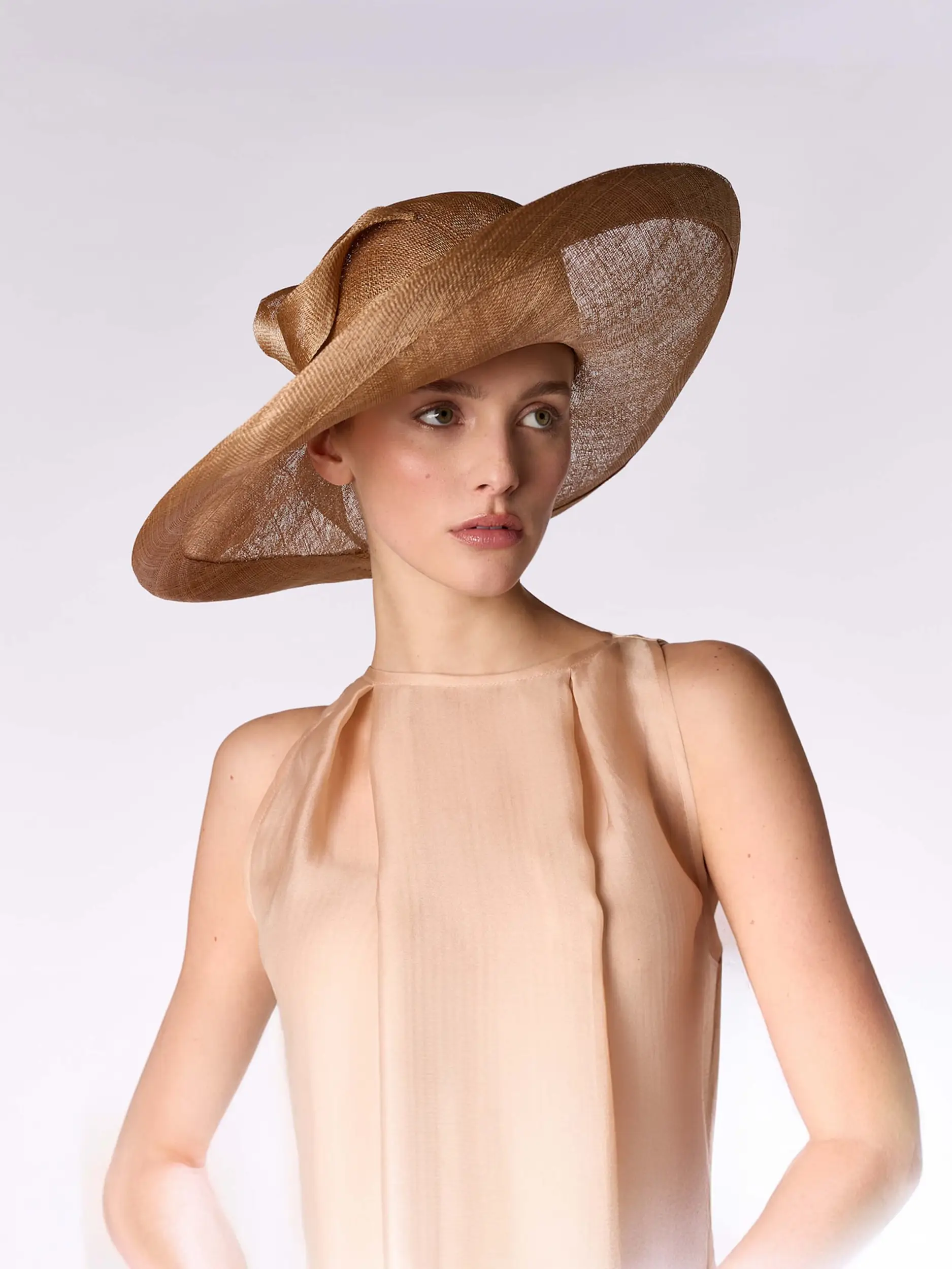 Woman wearing a caramel-coloured hat Maison Fabienne Delvigne