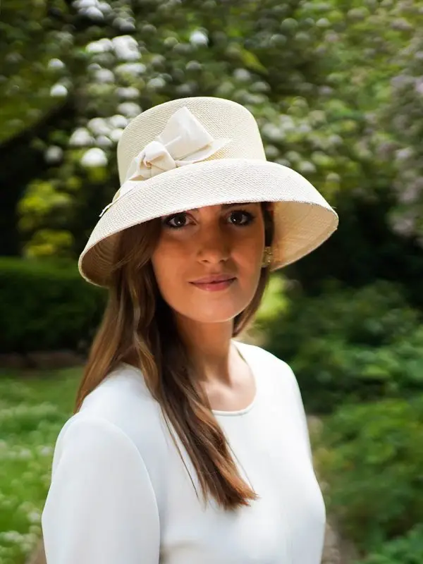 Mannequin wearing a natural-coloured straw Audrey cloche hat