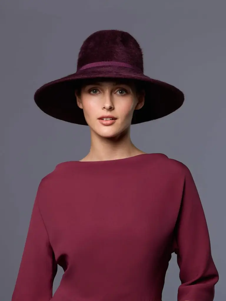 Woman wearing the Fedora cap with a velvet beige border from Adélaide, matched with her Maison Fabienne Delvigne outfit