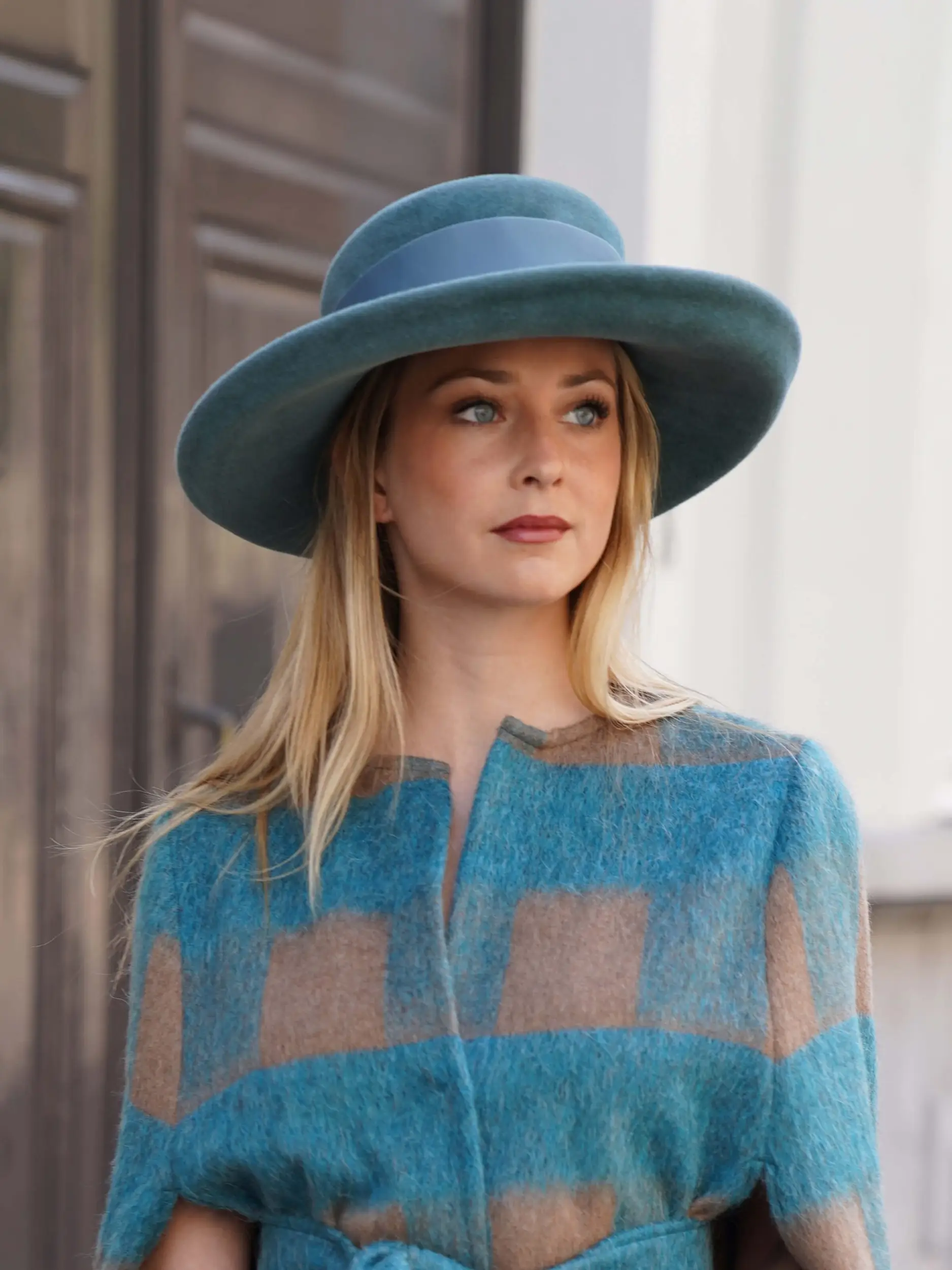 Woman wearing the Hidalgo cap with a green canard hat with a matching coat - Maison Fabienne Delvigne