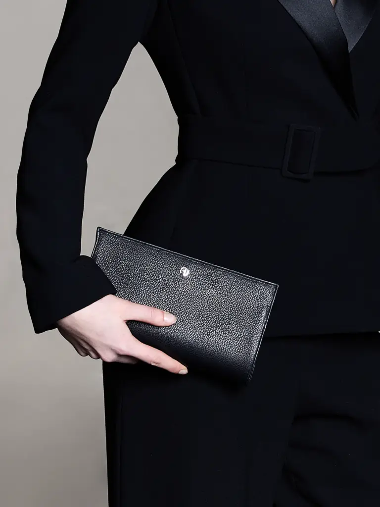 Woman carrying a black leather mourning clutch