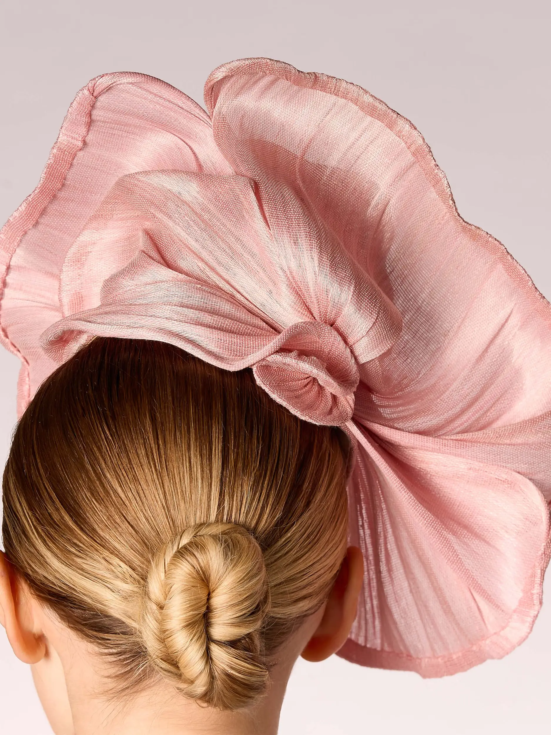 Back of a mannequin's head wearing a pink banana fibre hat and a bun hairstyle
