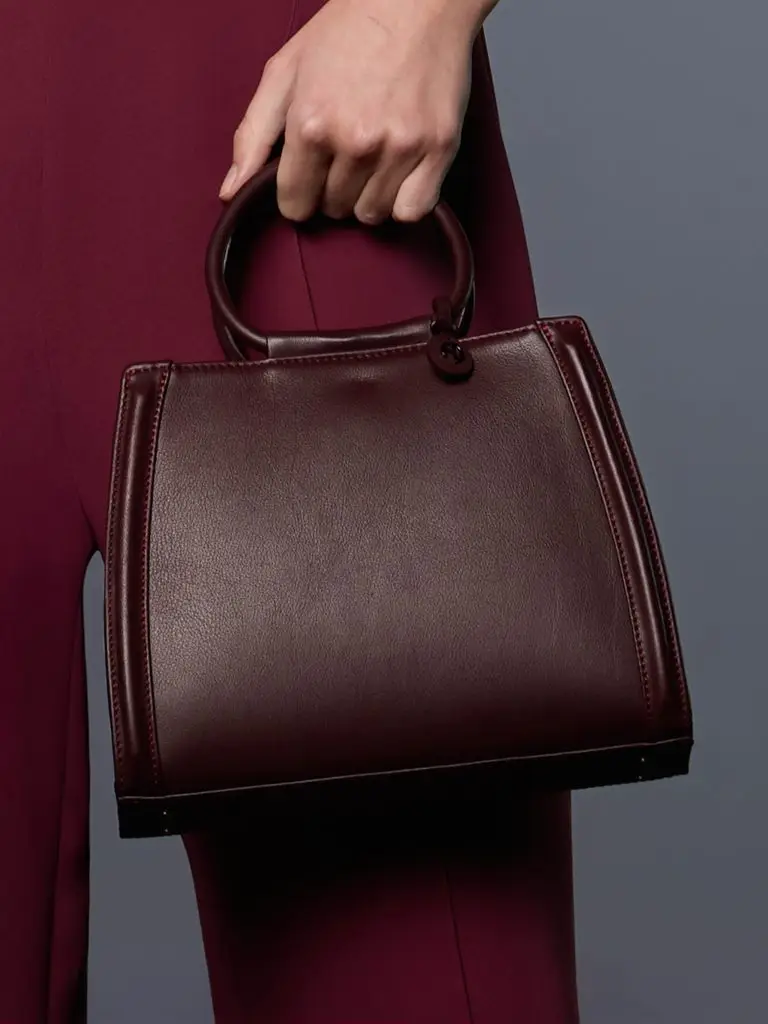 Mannequin wearing the burgundy leather handbag