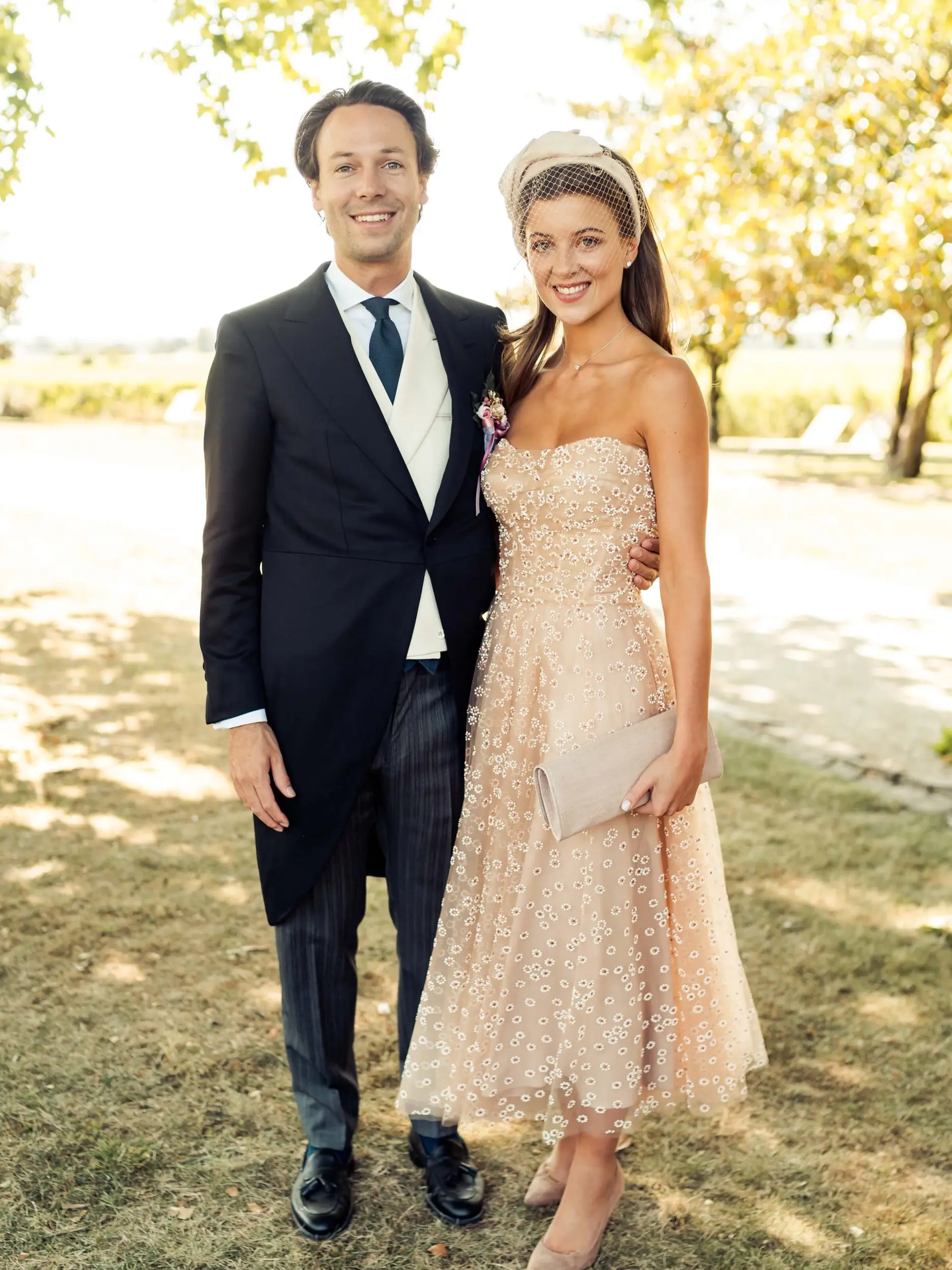 Couple posing with the beige rosé Colette wedding accessory from Maison Fabienne Delvigne