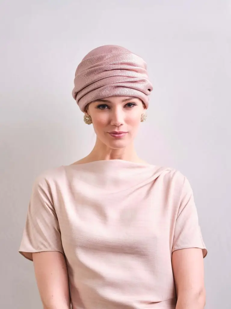 Woman wearing a powdered pink turban looking away - Valina Maison Fabienne Delvigne