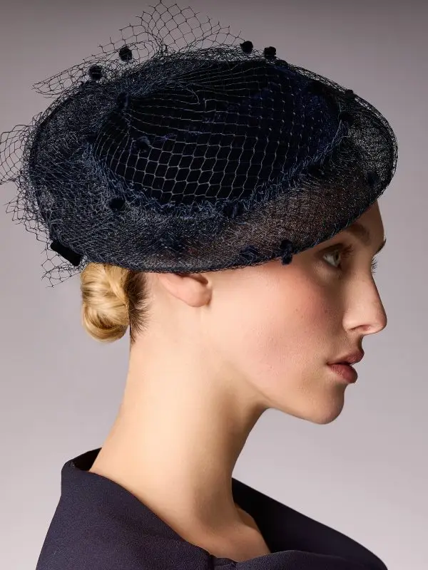 Woman wearing the bibi La Parisienne with a navy blue veil by Maison Fabienne Delvigne