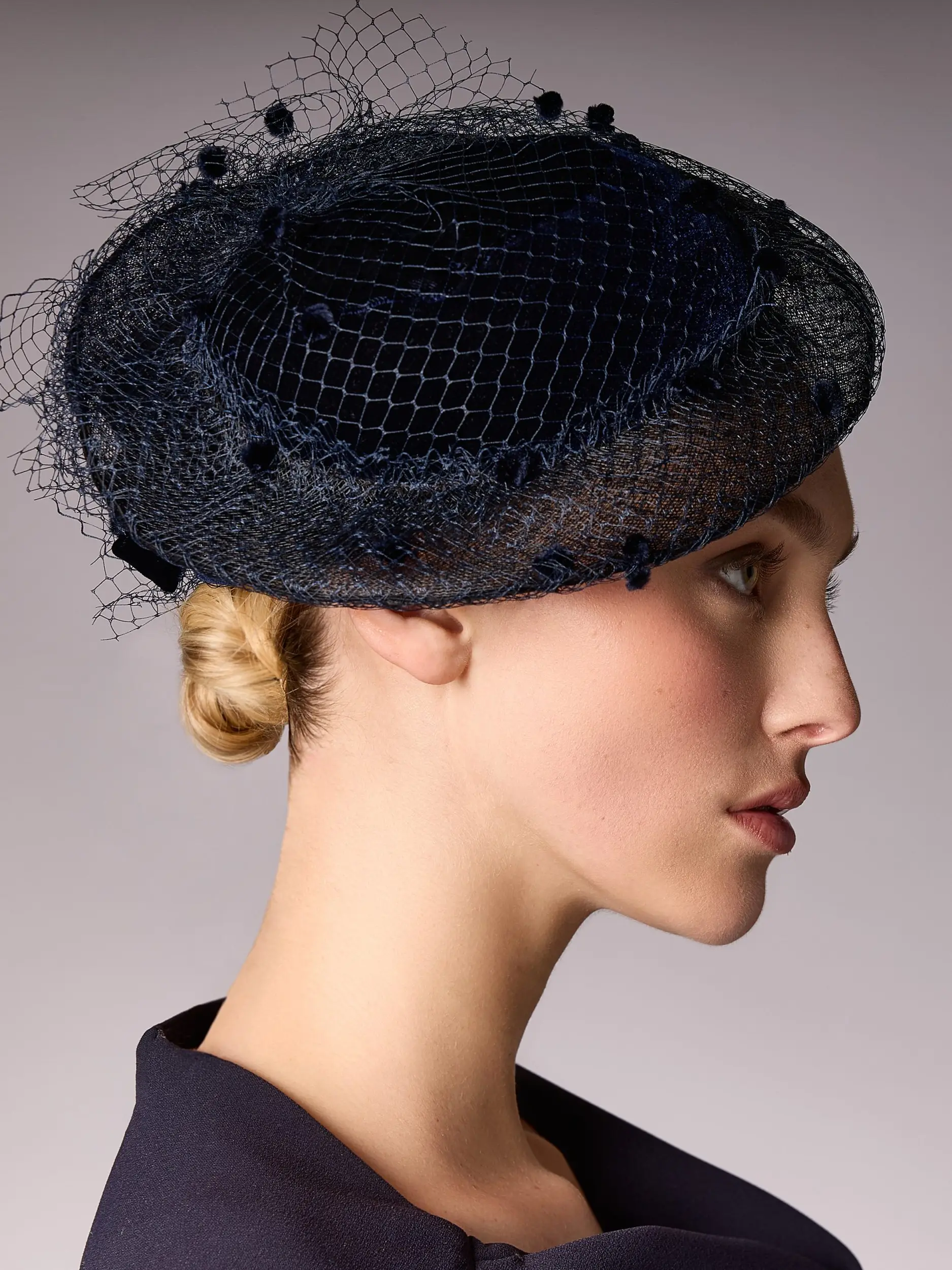 Woman wearing the bibi La Parisienne with a navy blue veil by Maison Fabienne Delvigne