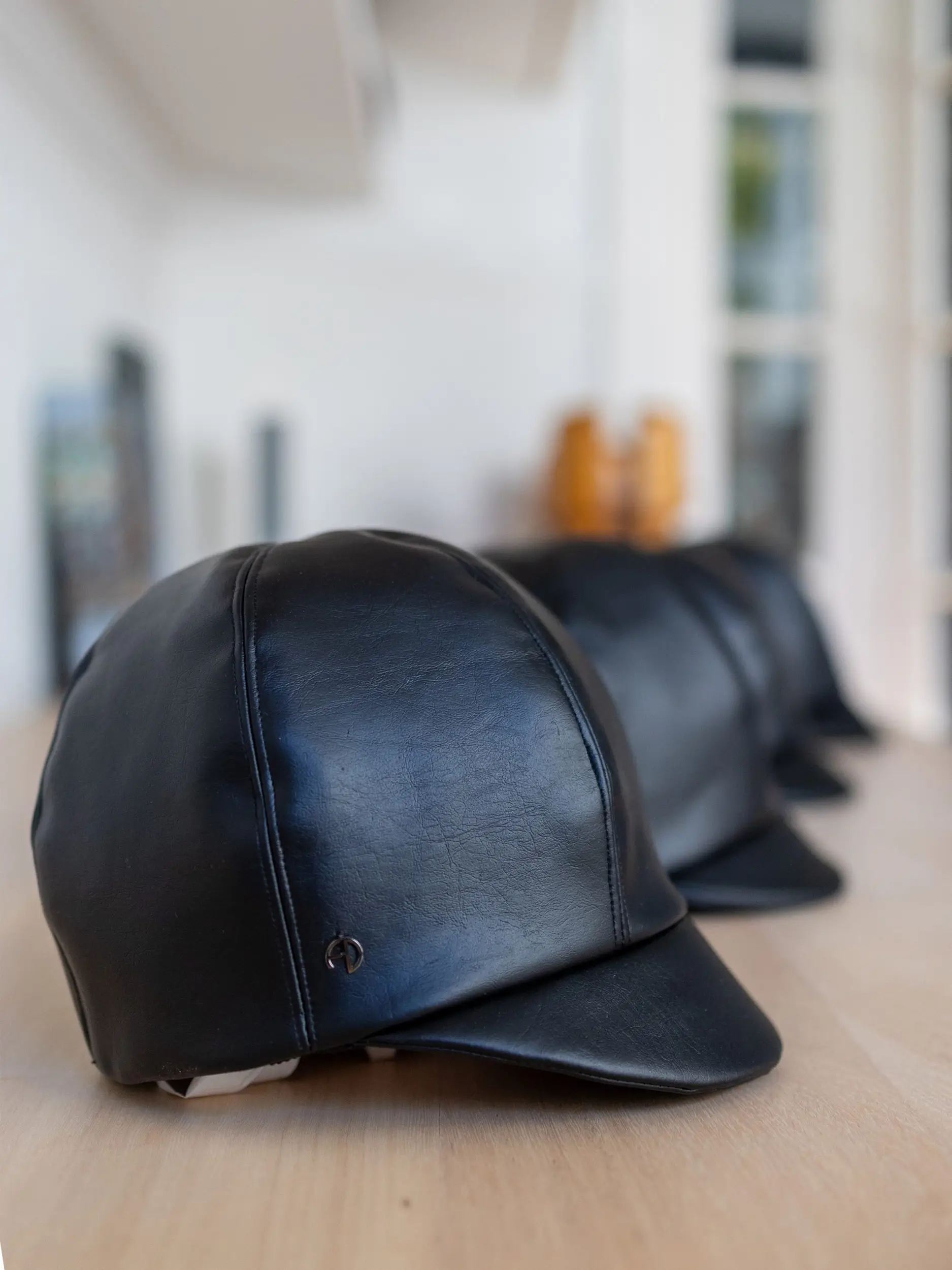 Several black leather caps lying on a table - Darie - Maison Fabienne Delvigne