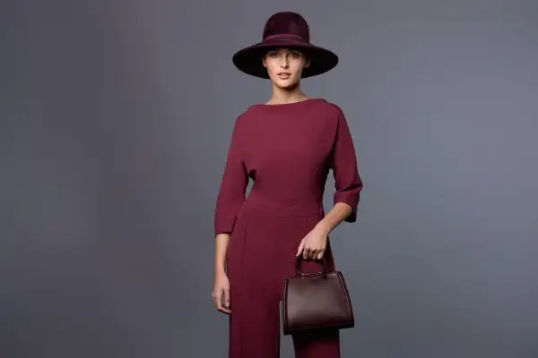 Woman wearing the Bellita bag in burgundy leather and the Adélaide fedora cap in burgundy felt by Maison Fabienne Delvigne