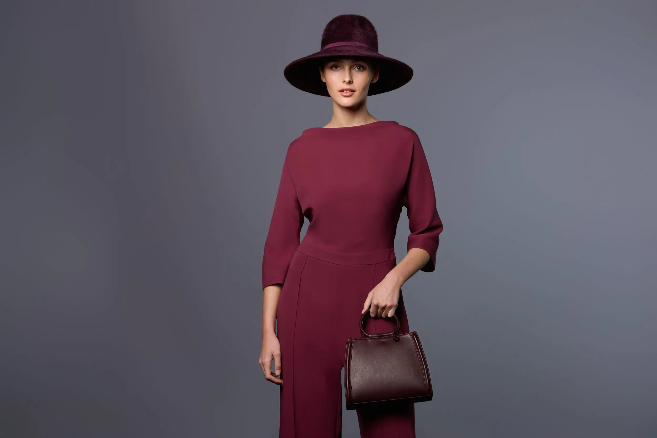 Woman wearing the Bellita bag in burgundy leather and the Adélaide fedora cap in burgundy felt by Maison Fabienne Delvigne