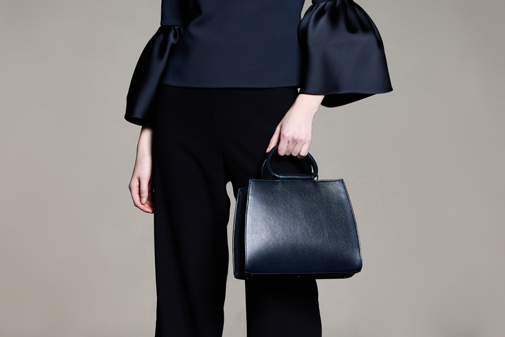 Model wearing the Bella navy blue leather handbag