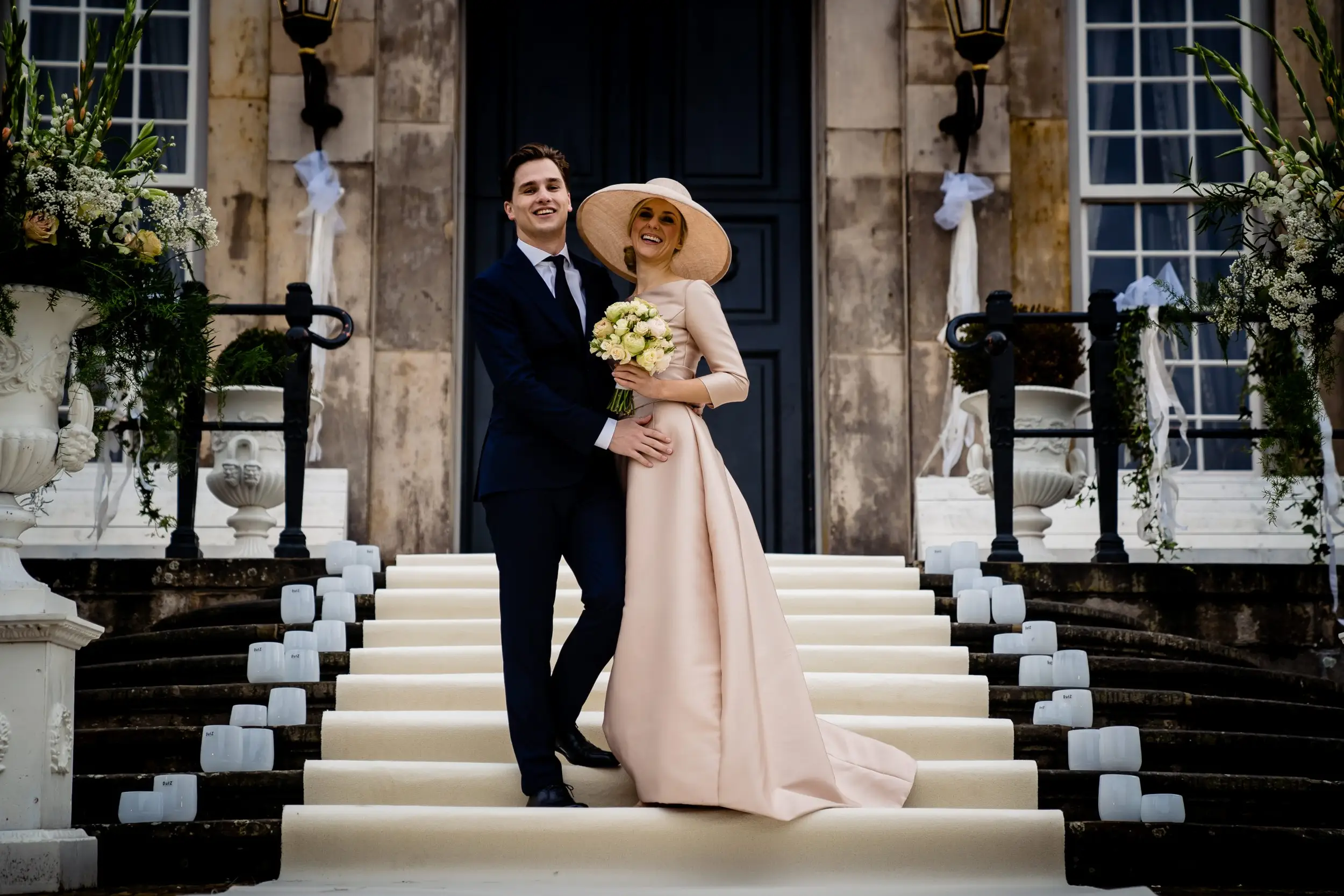 Couple of bride. The woman is wearing a beige pink hat that matches her dress