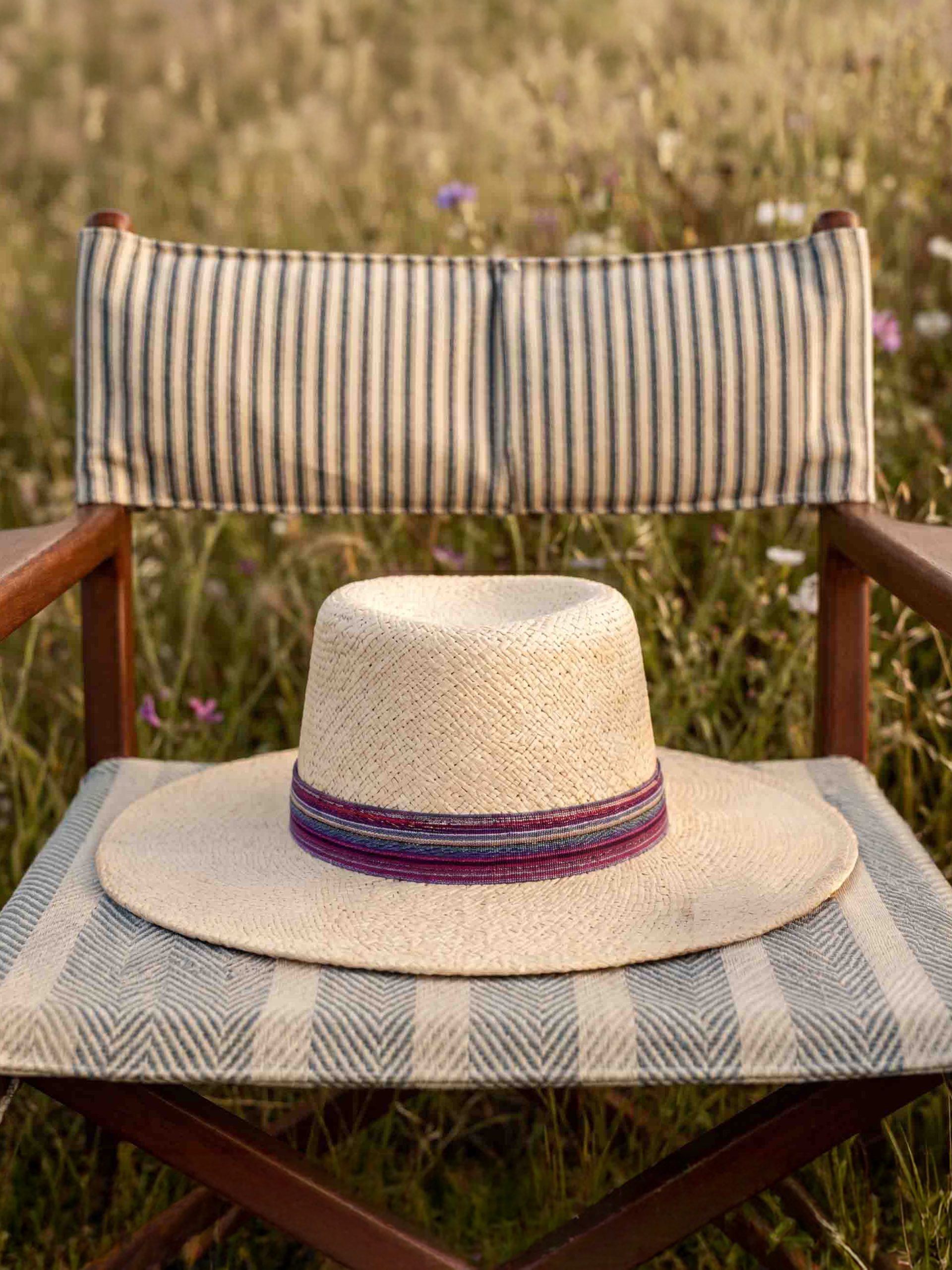 Natural capeliene sun hat fedora panama Marbella laid on a chair - Maison Fabienne Delvigne