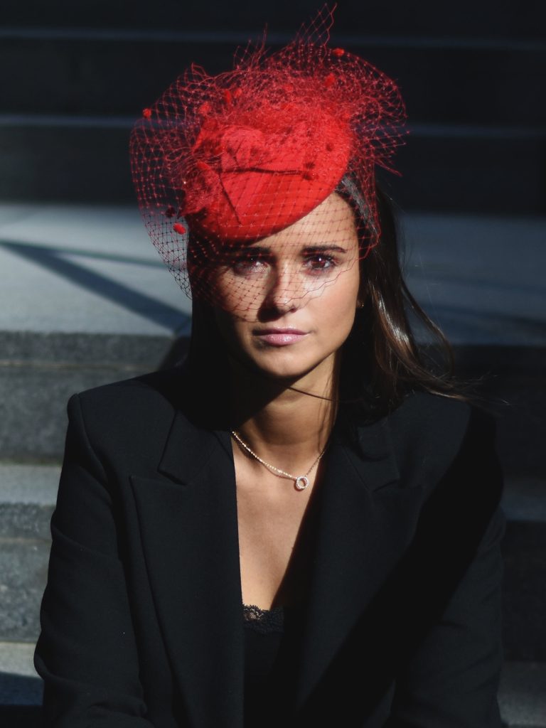 Woman wearing the bibi Follow me red accessory with the veil by Maison Fabienne Delvigne