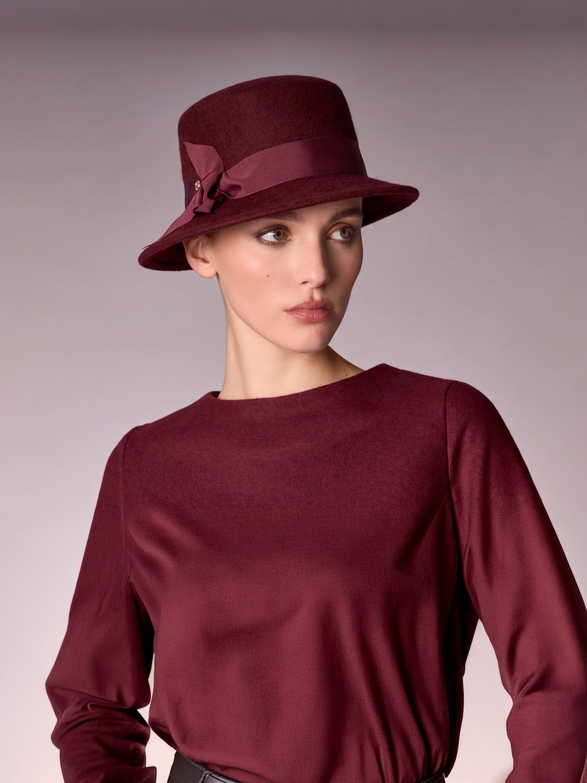 Woman wearing a cloche knitted hat in burgundy felt matched to her sweater