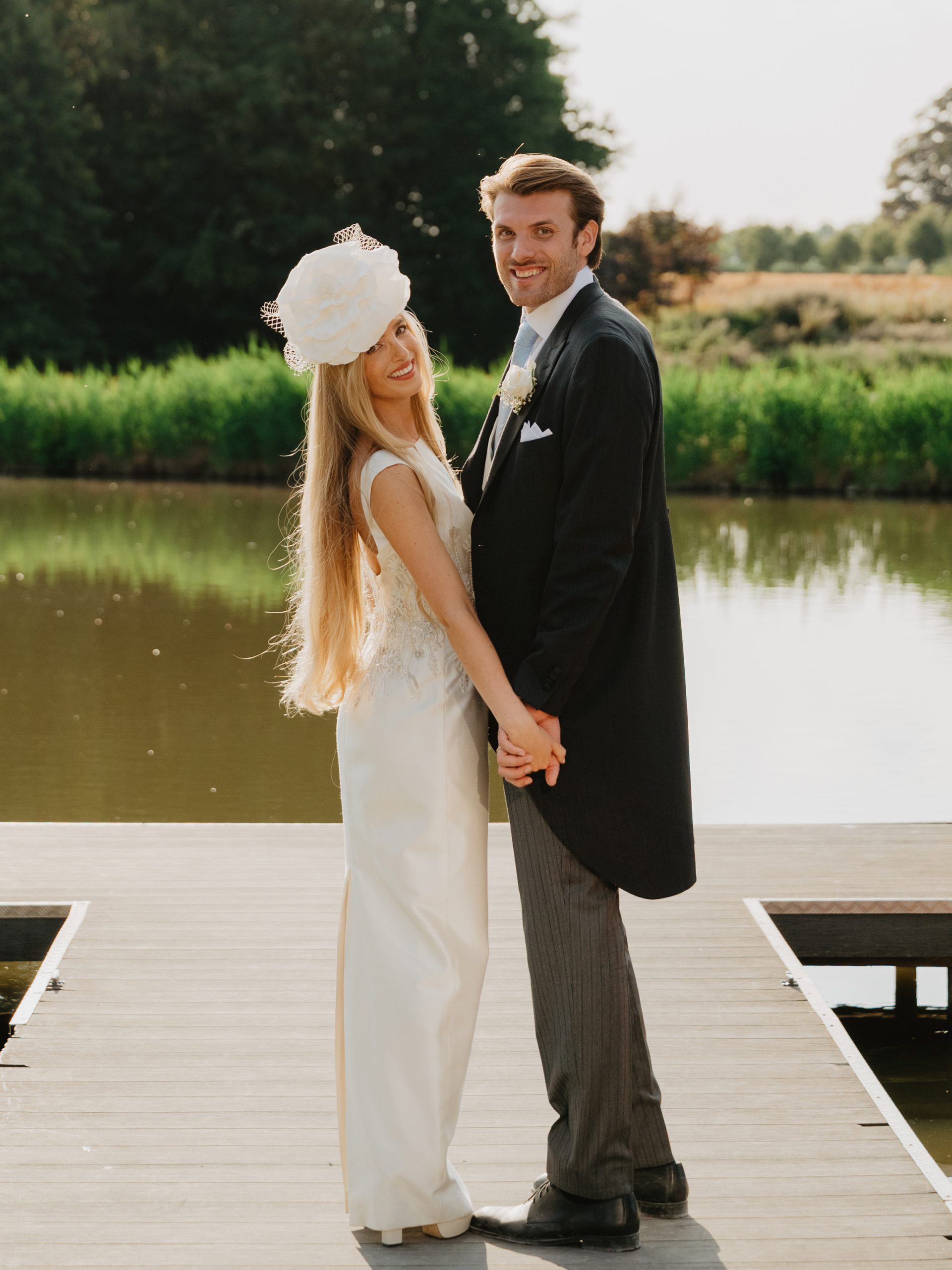 Couple of married people. The bride is wearing a hat with a large white rose - Désir Poudré - Maison Fabienne Delvigne